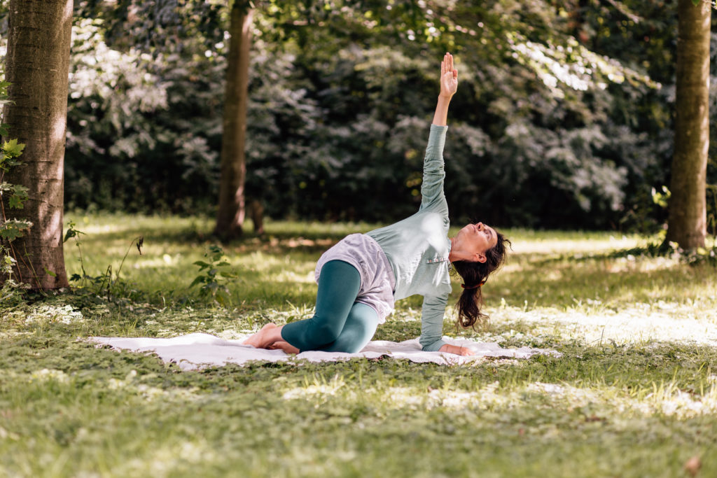 Die Yogalehrerin Maria Lichtenberg praktiziert den Seitwinkelstütz, der Kraft und Balance erfordert und richtet ihren Blick nach oben in der freien Natur (in der Nähe ihres Yogaraumes in Leipzig).