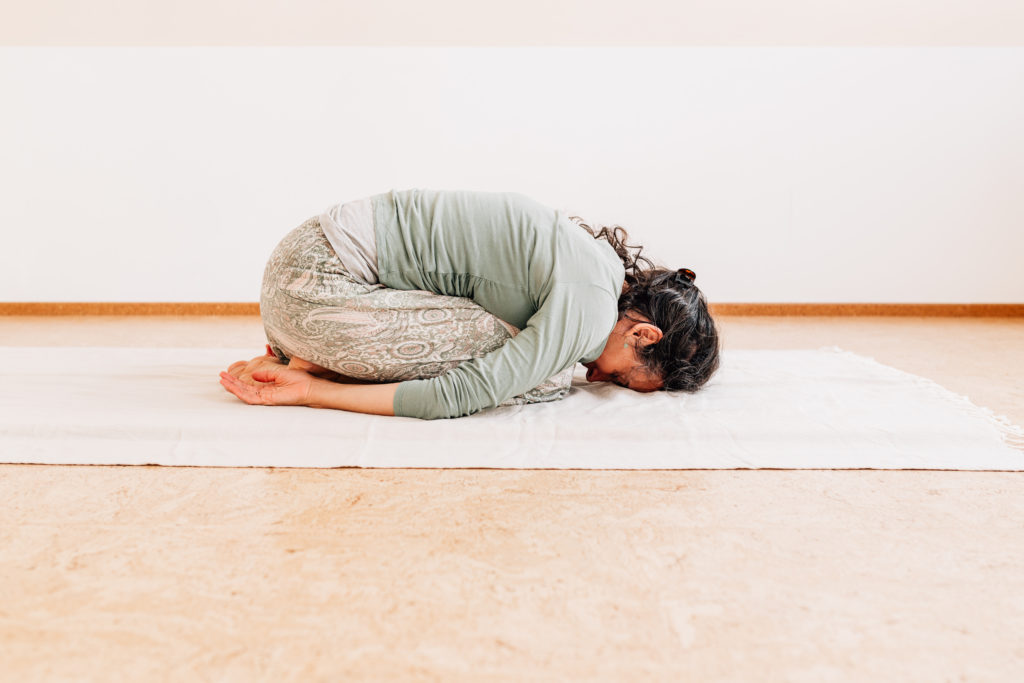 Die Yogalehrerin Maria Lichtenberg entlastet den unteren Rücken in der Kindshaltung in ihrem Yogaraum in Leipzig.