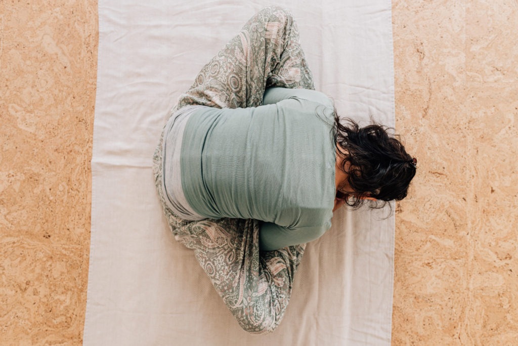 Die Yogalehrerin Maria Lichtenberg ergründet in einer Variante der Schildkröte/ Kurmasana einen Rückzugsort in sich selbst und lauscht dem eigenen Atem mit Ujjayi-Klang (aus der Vogelperspektive fotografiert) in ihrem Yogaraum in Leipzig.