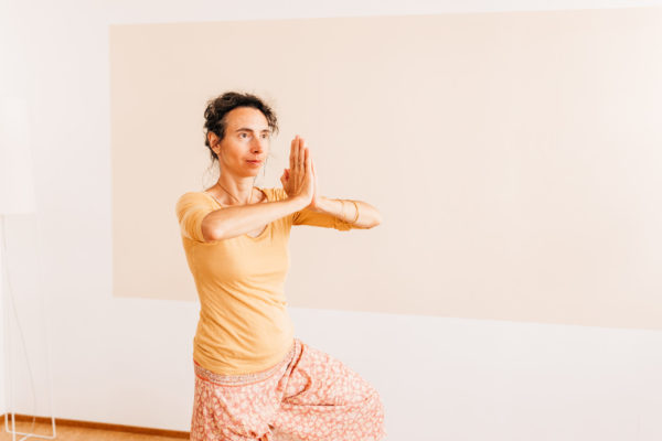 Die Yogalehrerin Maria Lichtenberg verweilt in der Berghaltung/ Parvatasana in ihrem Yogaraum in Leipzig.
