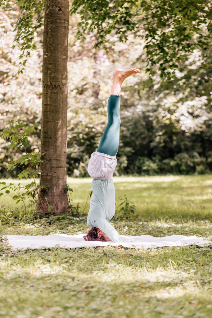 Die Yogalehrerin Maria Lichtenberg praktiziert den Kopfstand/ śīrṣāsana in der freien Natur (in der Nähe ihres Yogaraumes in Leipzig).